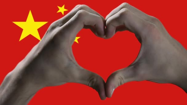 Vlag van China en Hand Hart Symbool, Handen Toont Hart Vorm Tegen Chinese vlag. Sluiten. - Video