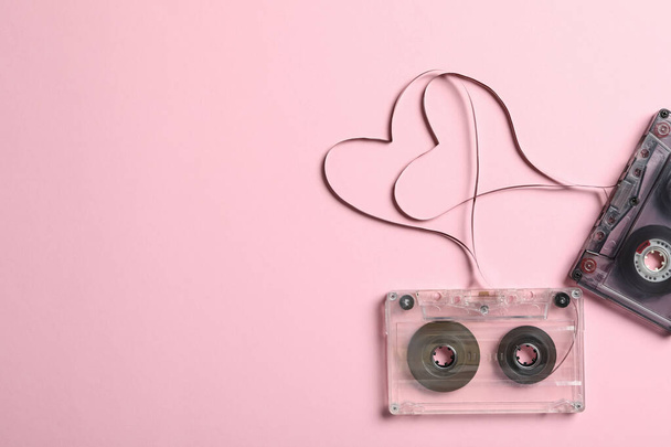 Music cassettes and hearts made of tape on pink background, flat lay with space for text. Listening love songs - Fotografie, Obrázek