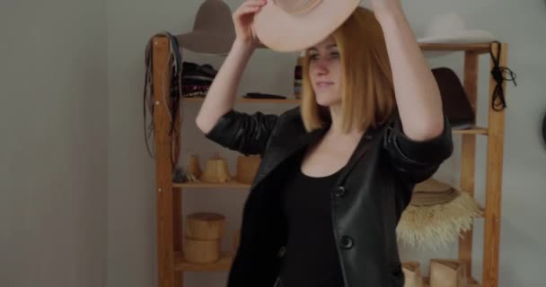 Ξανθιά γυναίκα βάζει στο χειροποίητο καπέλο τσόχα με πολύχρωμη κορδέλα στροφή στην κάμερα. Επαγγελματική miller επιδεικνύει τελικά καλύμματα κεφαλής που δημιουργήθηκε για την πώληση - Πλάνα, βίντεο