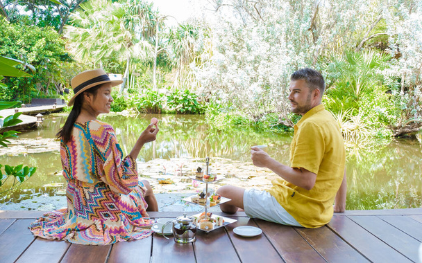 Thé de l'après-midi dans un étang d'eau, thé dans un jardin tropical en Thaïlande. Couple d'hommes et de femmes prenant le thé dans un jardin tropical - Photo, image