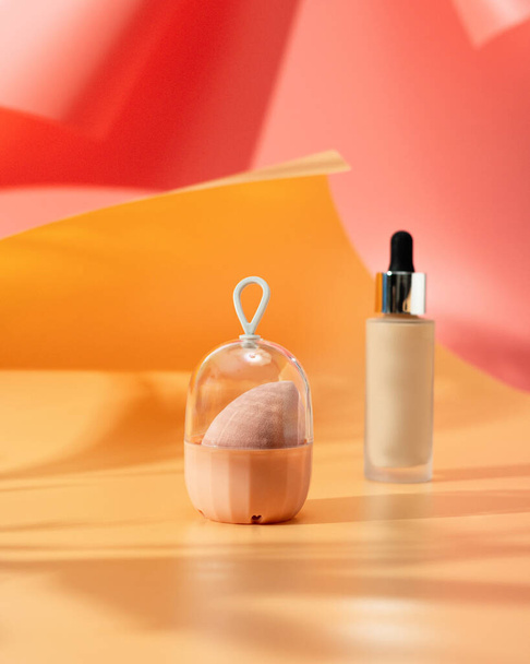 Esponja de maquillaje sobre un fondo amarillo-rosa - Foto, imagen