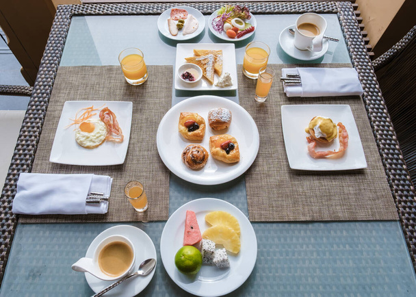 Bovenaanzicht op een luxe ontbijt met koffie, eieren, brood en croissant.  - Foto, afbeelding