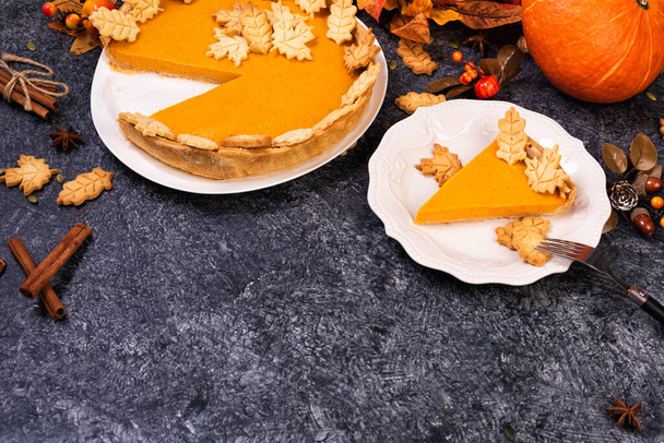 シナモンと大理石のテーブルの上に松の実と自家製スパイシーなカボチャのパイ。感謝祭の日のための伝統的な秋の甘いデザート - 写真・画像