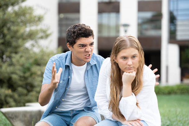 Chico hispano enojado y agresivo gritando y amenazando a su novia al aire libre. Relación tóxica en el concepto de adolescencia - Foto, imagen