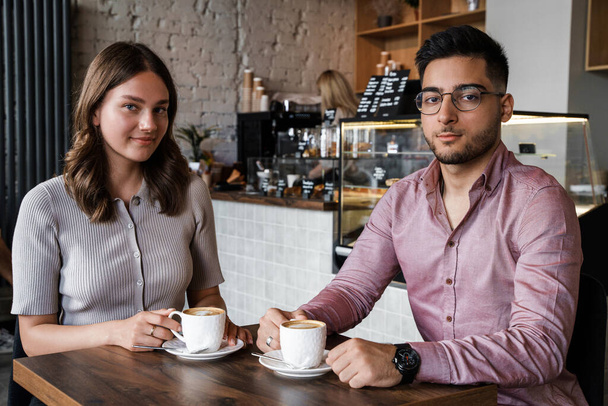 Tourné de l'homme avec sa petite amie relaxant boire du café dans le café moderne. - Photo, image