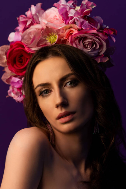 Portrait of an attractive young Ukrainian woman wearing a beautiful wreath of pink roses. Headdress for a girl. Concept wedding style or beauty salon and skin care. High quality photo - Fotografie, Obrázek