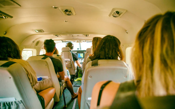 AIRLIE BEACH, AUSTRALIA - 25 августа 2018 года: Туристы на маленьком самолете в аэропорту Whitsunday готовы к экскурсии по островам. Город является воротами на острова Уитсандэй.
. - Фото, изображение
