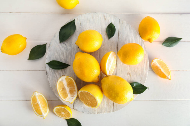 Дошка зі свіжими лимонами на світлому дерев'яному фоні
 - Фото, зображення
