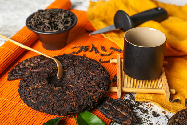 Dry pressed puer tea, chashaku and cup on table, closeup - Фото, зображення