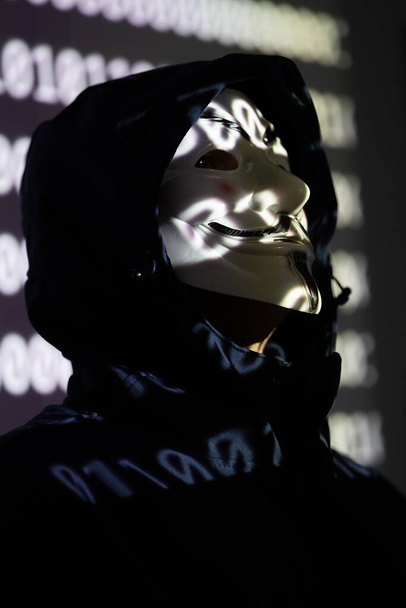 Brussels, Belgium - September 16, 2022: Hooded identity theft wearing an Anonymous Guy Fawkes mask - Photo, Image
