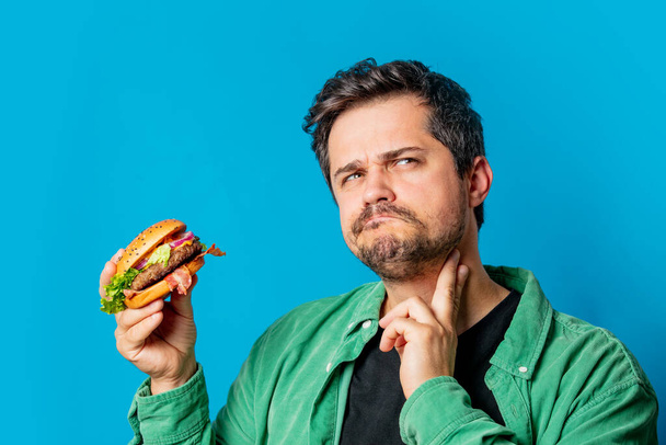 branco cara no verde camisa com hambúrguer no azul fundo - Foto, Imagem