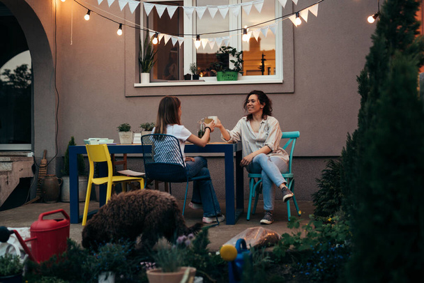mother and daughter spending time together outdoor in home backyard - Photo, image