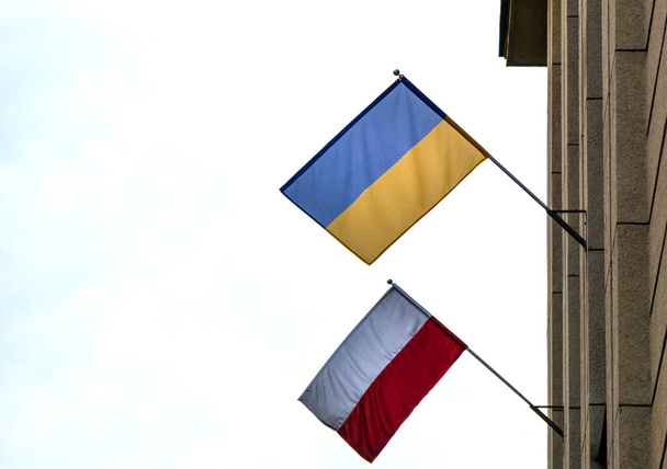 Le drapeau de la Pologne et de l'Ukraine ensemble sur la façade du bâtiment. C'est un symbole d'opposition à l'agression russe, un signe de solidarité et d'aide à l'Ukraine - Photo, image