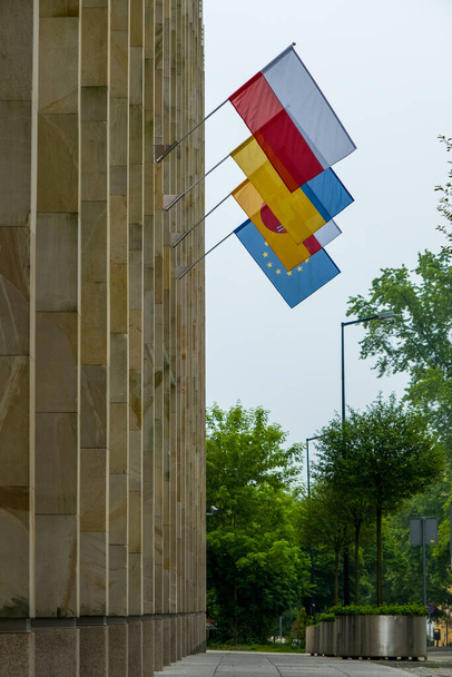 Ofis binası arka planında Polonya, Ukrayna, Lublin Voyvoda ve Avrupa Birliği bayrakları. Rus saldırısına karşı bir sembol, dayanışma işareti ve Ukrayna 'ya yardım. - Fotoğraf, Görsel