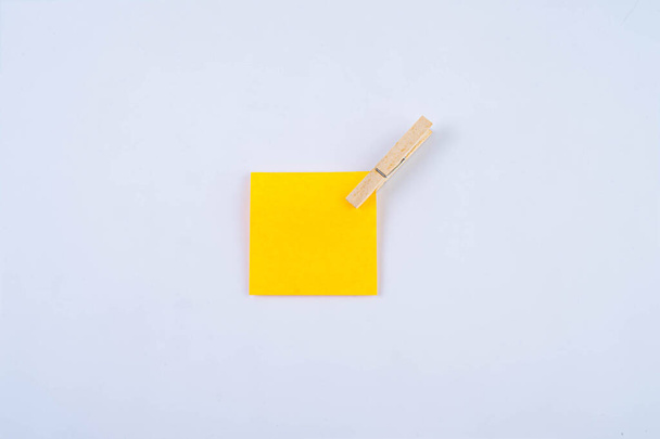 Oranje notitie met houten clip geïsoleerd op wit  - Foto, afbeelding
