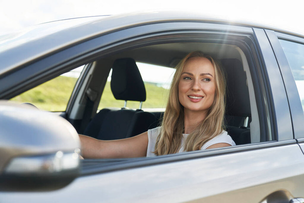 Caucasian adult blonde woman driving a car - Zdjęcie, obraz