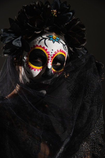 γυναίκα στην παραδοσιακή ημέρα του νεκρού μακιγιάζ συσκότιση πρόσωπο με σκούρο πέπλο απομονώνονται σε μαύρο - Φωτογραφία, εικόνα