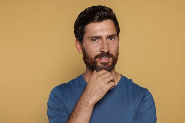 Portrait of handsome bearded man on yellow background - Photo, Image