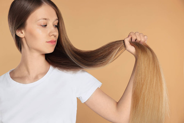 Teenage girl with strong healthy hair on beige background - Foto, Bild