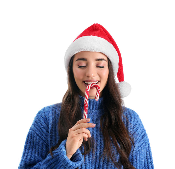 Beautiful woman in Santa Claus hat holding candy cane on white background - Φωτογραφία, εικόνα