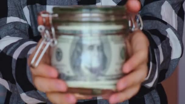 Dollar banknote saving money in glass jar. Unrecognizable woman moderate consumption and economy Collecting money. Tips. Business, finance, saving, banking and people concept. Extra money, passive - Metraje, vídeo
