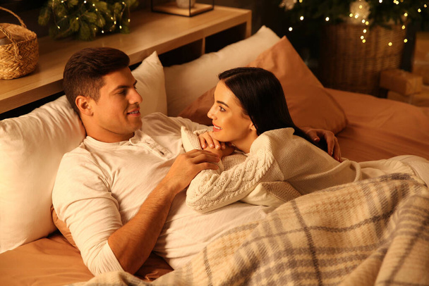 Happy couple in bed at home. Christmas celebration - Φωτογραφία, εικόνα