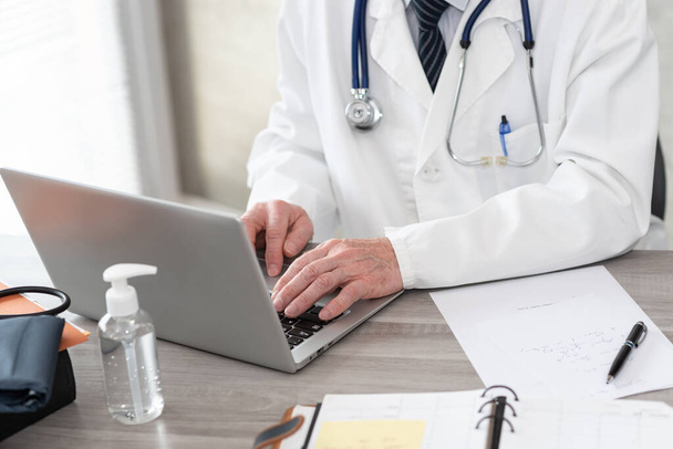 Arzt mit Laptop in Arztpraxis - Foto, Bild