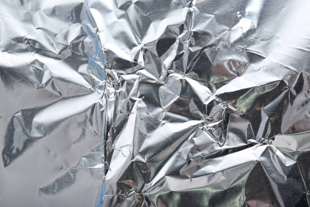 Crumpled silver foil as background, closeup view - 写真・画像