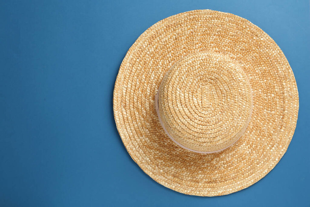 Stylish straw hat on blue background, top view. Space for text - 写真・画像