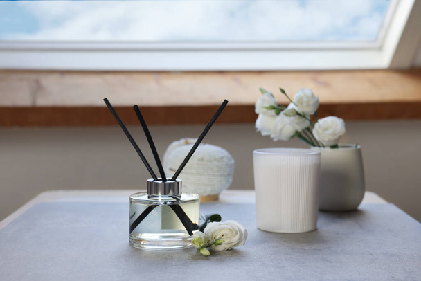 Reed diffuser, scented candle and eustoma flowers on gray marble table - Фото, зображення