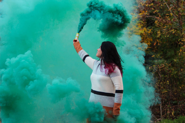 Vrouw met een groen gekleurde rook  - Foto, afbeelding