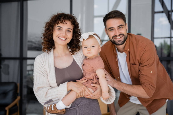 portrait of happy family with infant baby girl looking at camera - Foto, imagen