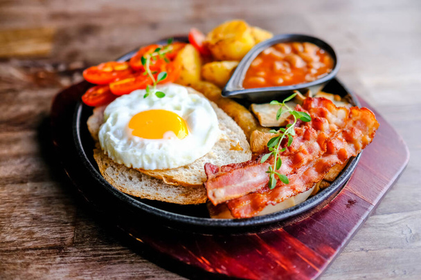 Yumurta, fasulye, pastırma ve kızarmış patatesle nefis bir İngiliz kahvaltısı.. - Fotoğraf, Görsel