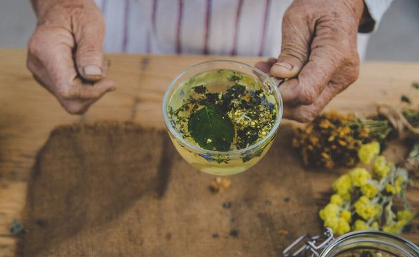 Grand-mère fait du thé avec des herbes médicinales. Concentration sélective. Nature. - Photo, image