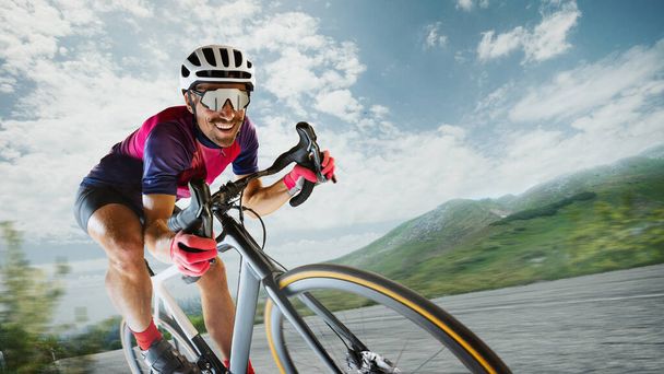 Портрет веселого человека, профессионального велогонщика в специальной униформе, катающегося на спортивном велосипеде по природному ландшафту. Спорт, образ жизни, здоровье, тренировки на свежем воздухе, скоростное развитие - Фото, изображение