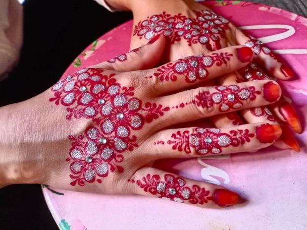 close-up van rode handen met een mooie bloem - Foto, afbeelding