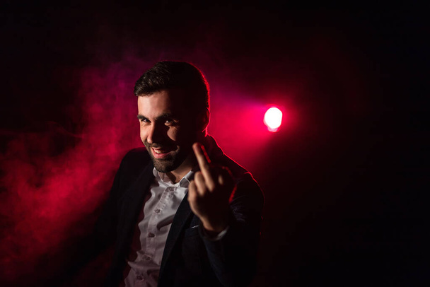 Close up photo of man showing middle finger on pink and black background. Concept of man showing middle finger. - Φωτογραφία, εικόνα