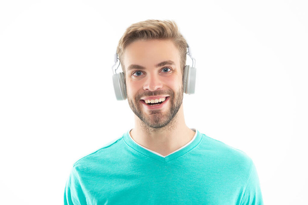 Portrait of happy guy listening to music isolated on white studio. Guy with smiling face wearing headphones for music. Enjoying joyful music. Having fun leisure lifestyle. - Photo, image