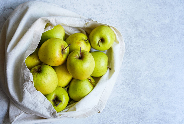 Eco-bag full of green apples on white background - Фото, зображення