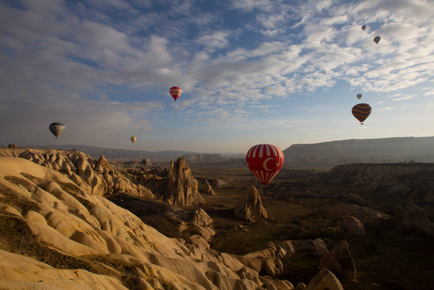 Balloons flying in Cappadocia, Greme at sunrise. Cappadocia is known around the world as one of the best places to fly with hot air balloons.  - Foto, afbeelding
