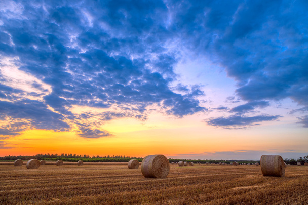 Sunset over rural road and hay bales - Photo, Image