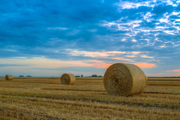 Sunset over rural road and hay bales - Photo, Image