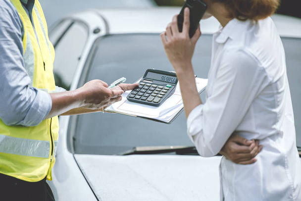 A gépjármű-ügynöki tiszt szolgáltatási költséget mutat a női sofőrnek. hölgy vesz egy autó garázs számítás ajánlat pénz értéke. - Fotó, kép