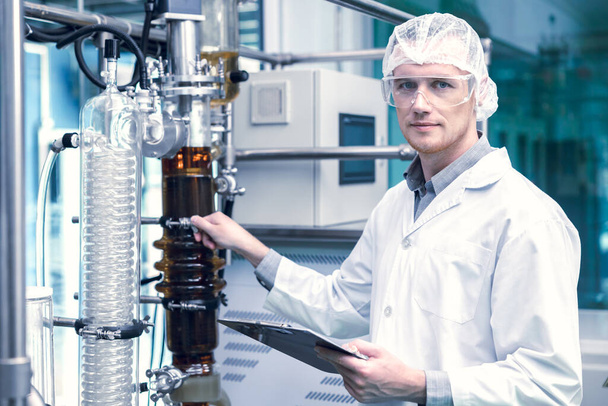 medicine factory scientist worker with Cannabis CBD oil extraction machine. Hemp oil extraction Thin Film Distillation Laboratory Plants Process. - Fotoğraf, Görsel