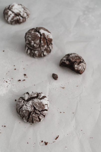 Biscoitos gelados de chocolate Crinkle dispostos em uma superfície de trabalho de cozinha de mármore branco com espaço de cópia disponível. Imagem de conceito de cozimento em casa. - Foto, Imagem