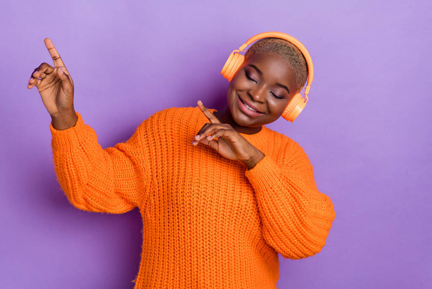 Photo of attractive young lady have fun dancing relaxing dressed trendy autumn orange knitted sweater isolated on violet color background. - Φωτογραφία, εικόνα