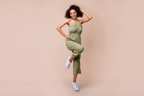 Full length photo of nice young girl wavy hair posing enjoy shopping promoter dressed stylish khaki look isolated on beige color background. - Fotoğraf, Görsel