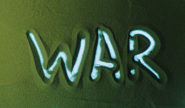Kézzel rajzolni a Zöld Homokban a világháborút. Férfi kéz írja a szót Háború a zöld homok fehér háttérvilágítással. Felülnézet 4k felbontás - Fotó, kép
