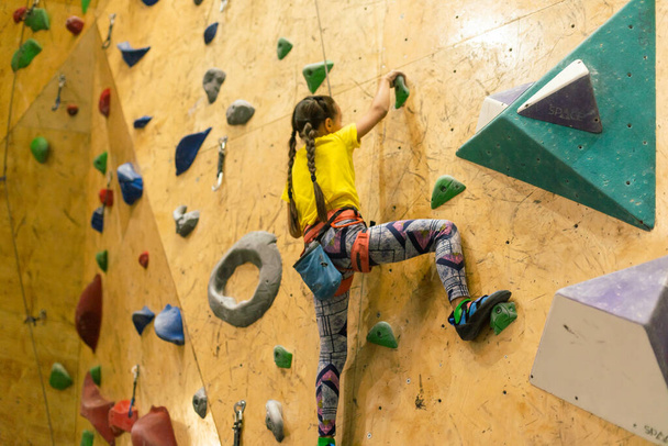 Pieni tyttö kiipeily Rock Wall Indoor
. - Valokuva, kuva