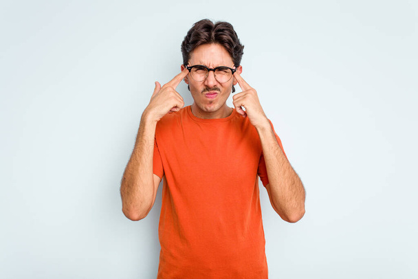 Молодий іспаномовний чоловік ізольований на синьому фоні, орієнтований на завдання, тримаючи палець, спрямований на голову
. - Фото, зображення